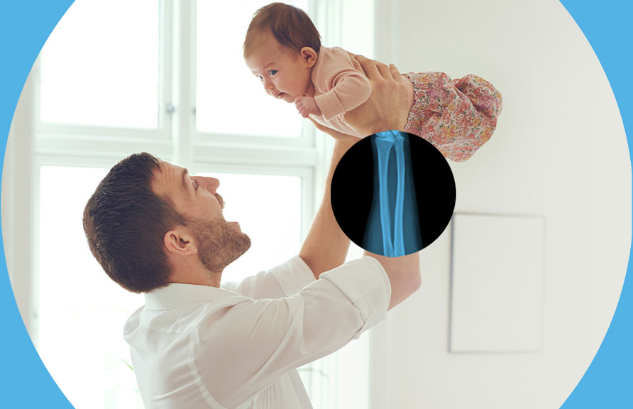 Image of a father lifting baby with x-ray of arm